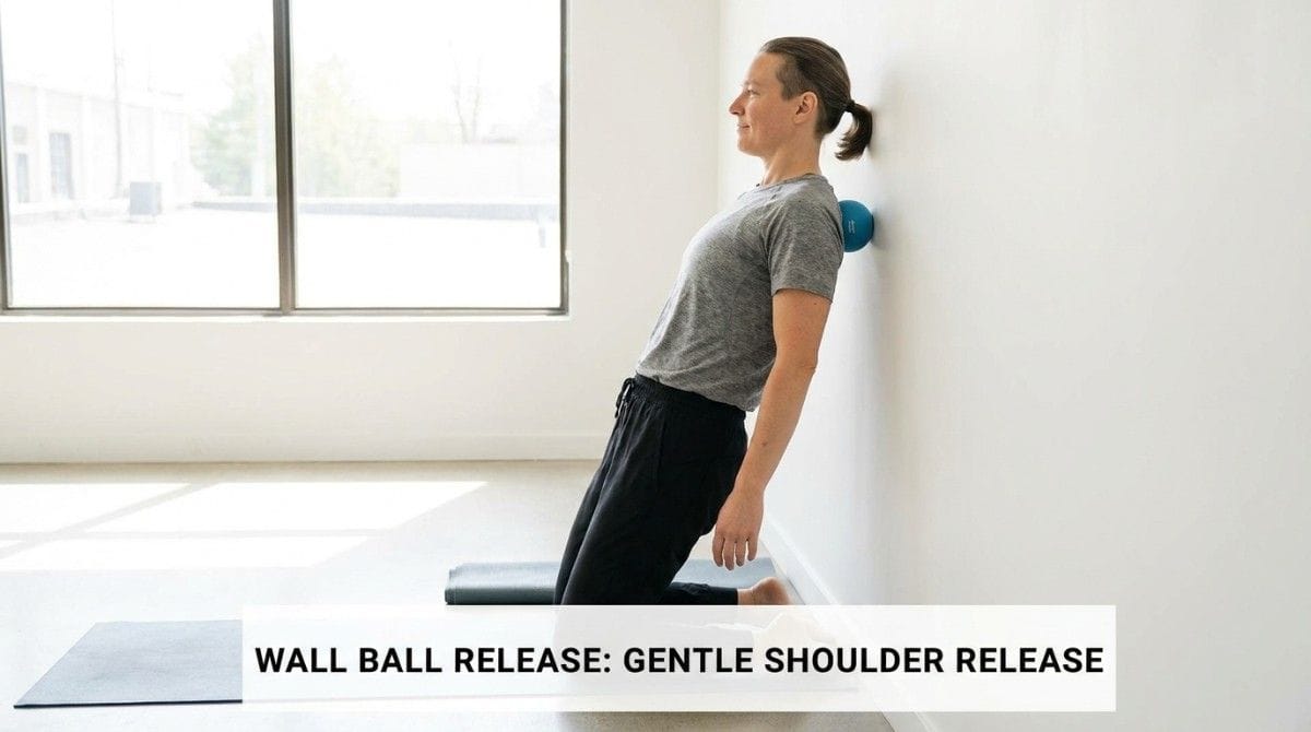 Person performing a wall ball massage to release shoulder and upper back tension.